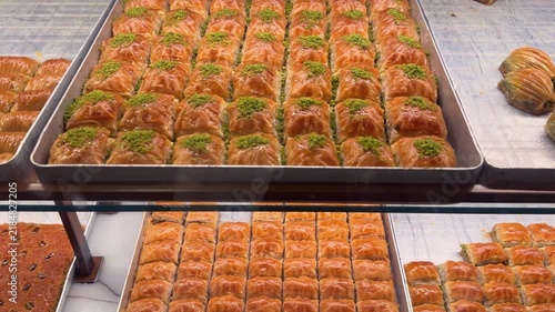 Assortment of traditional Turkish baklava pastries displayed in a glass shop window in Istanbul, Turkey. 