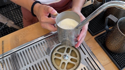Close-up video of a barista steaming and frothing milk with a professional espresso machine for cappuccino, latte and other milk-based coffee drinks