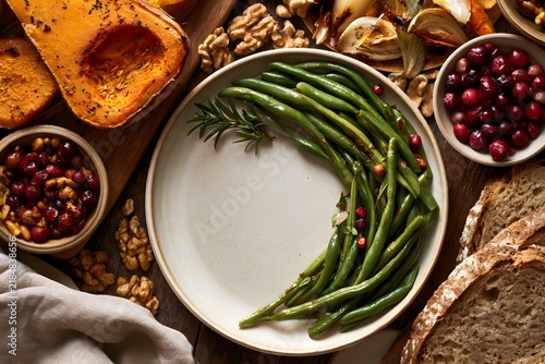 Thanksgiving harvest flat lay with roasted squash and green beans