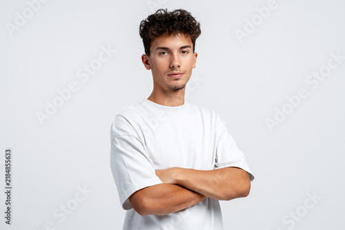 Bild auf Leinwand Young man posing with crossed arms feeling confident