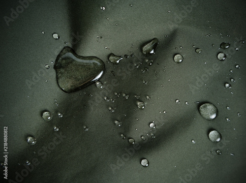 Фотография Water drops on dark green hydrophobic textile close-up