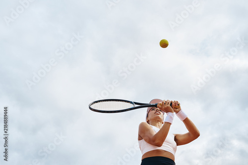 Bild auf Leinwand Young adult multiethnic woman preparing two handed backhand stroke during tennis training outdoors