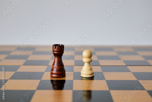 Cuadro en lienzo Dark rook and white pawn stand alone on an otherwise empty chessboard