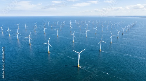Offshore wind farm with turbines in the ocean, renewable energy power plant aerial view.