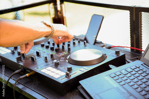 Dj performing music with controller and laptop