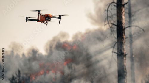 Plakat Camera drone hovering over a burning forest with smoke and flames