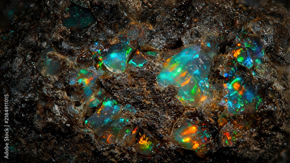 Obraz premium Fiery Opal Glows Inside Ancient Dark Stone