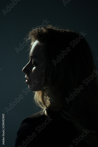 Young Woman Looking Away in Dark Studio Portrait
