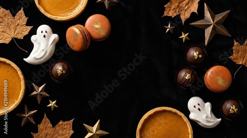 Halloween dessert flat lay with pumpkin pies ghost meringue and festive sweets