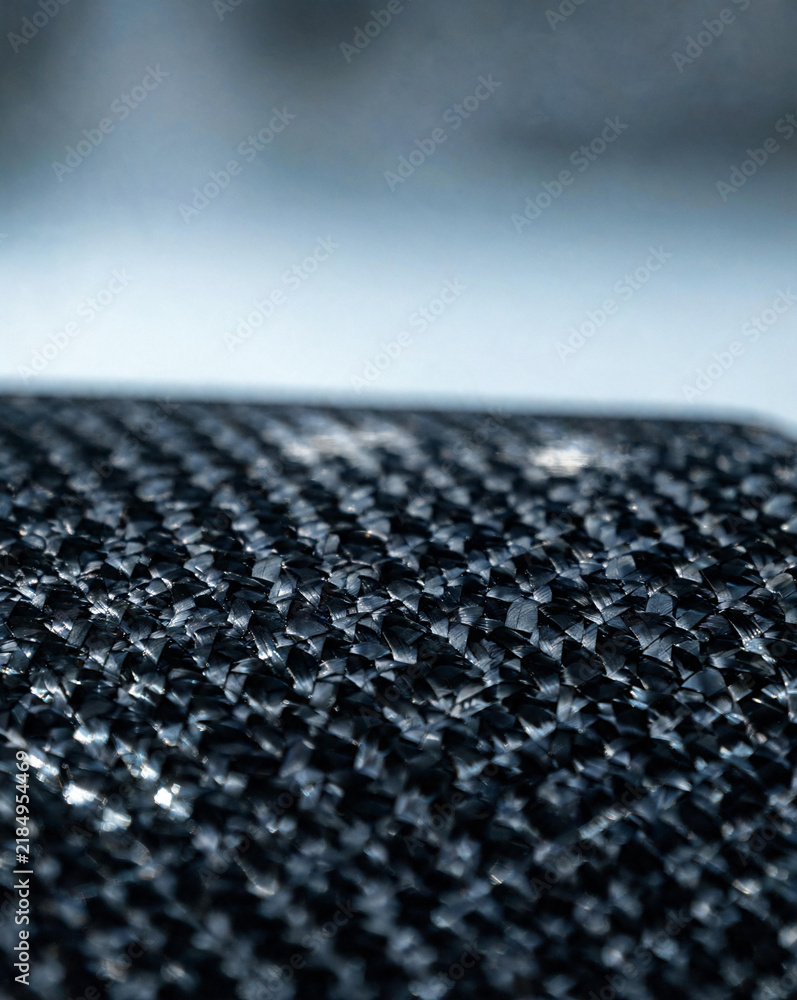 Fototapeta premium Macro close-up of carbon fiber weave with glossy resin coating texture