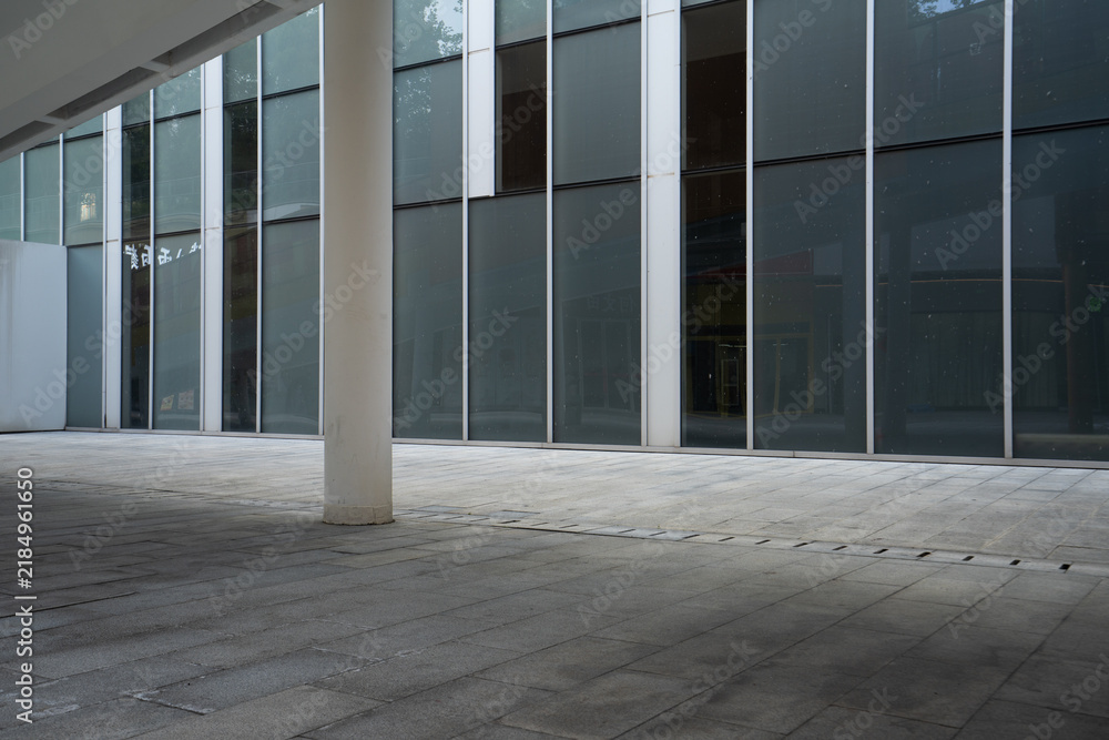 Obraz premium Empty plaza under modern building glass curtain wall