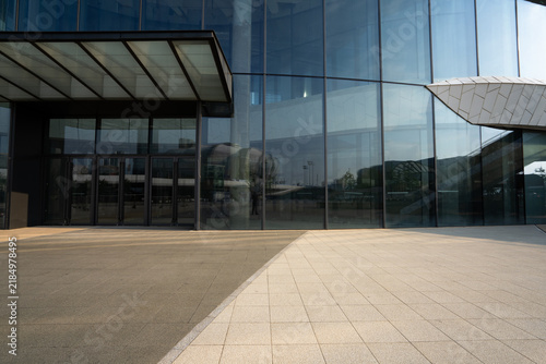 modern glass curtain wall building entrance with paved plaza