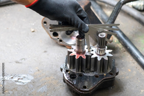 Konstfotografi Mechanic inspects gear clearance of hydraulic pump using feeler gauge inside workshop