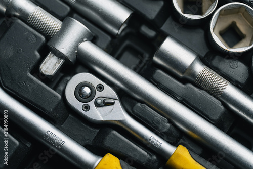 Close up shot of mechanical tools, ratchet handle and extension bars in organized toolbox case. Garage repair kit, workshop equipment and car service concept.	
