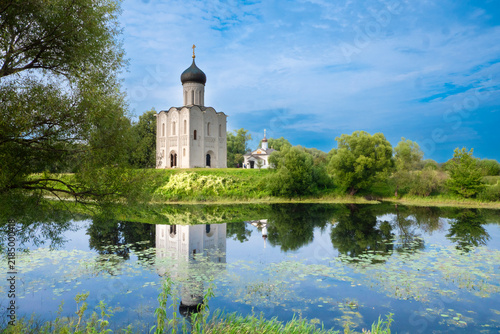 Bild auf Leinwand Church of the Intercession on the Nerl with Reflection in River Surrounded by Tr