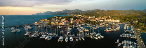 Saint Florent coastal town Corsica island 8K drone panorama Golden hour sunset marina white boats and mountains. High resolution World Print fine art aerial landscape stock photo