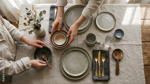 People Setting Table In Home Dining Room