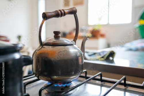 Obraz na płótnie Vintage metal kettle heating water over gas stove flame in home kitchen