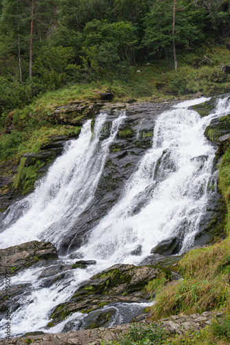 Svandalsfossen waterfall cascading over mossy rocks in a lush Norwegian landscape