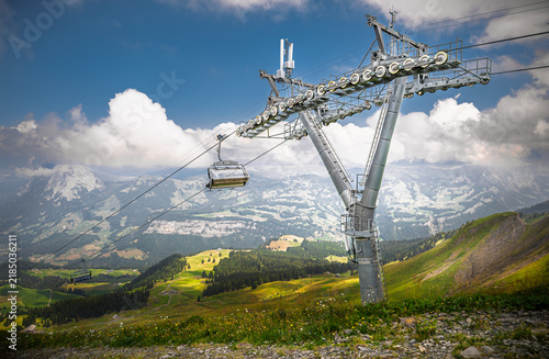 Modern 6-seater chairlift transports passengers over scenic Swiss Alps landscape