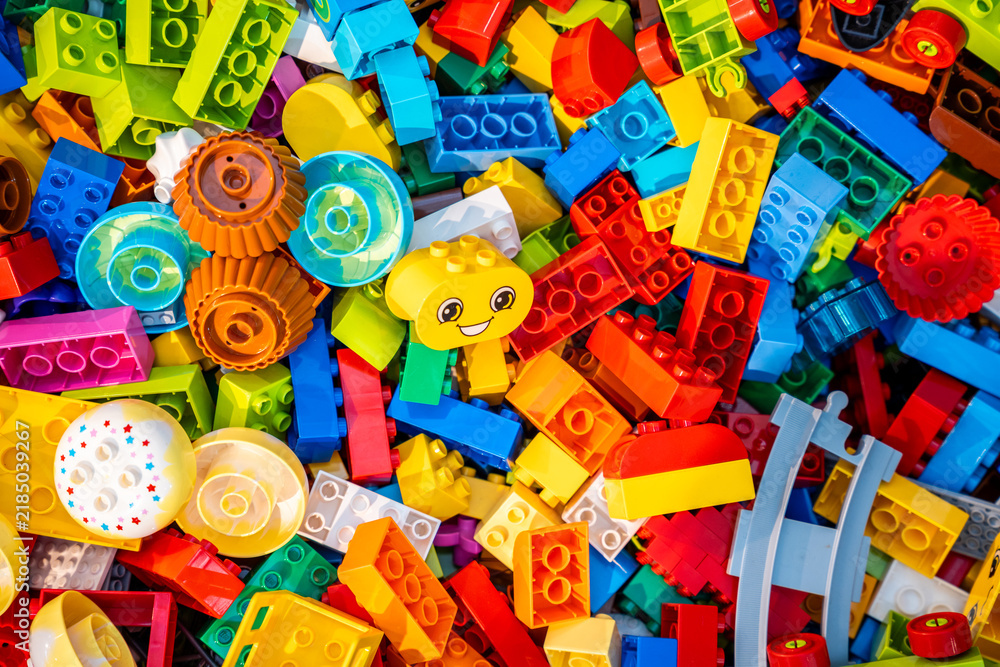 Obraz premium Top view A pile of multicolor of many Lego toy blocks in various shapes and different sizes. Toys and games. Leisure and recreation.