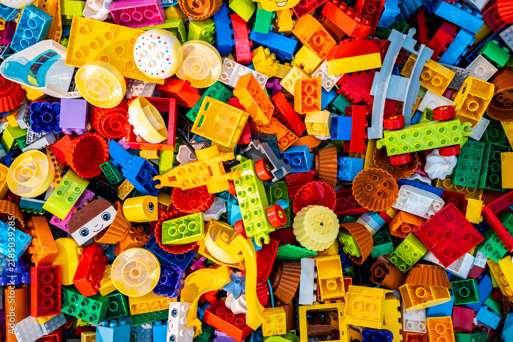 Obraz premium Top view A pile of multicolor of many Lego toy blocks in various shapes and different sizes. Toys and games. Leisure and recreation.