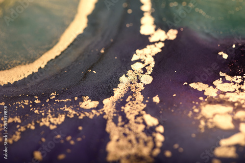 Abstract background of purple-green and gold stains. Photo of the surface.