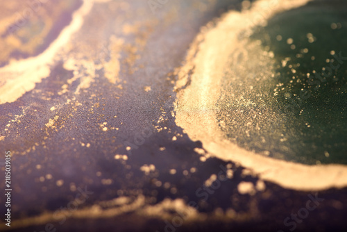 Abstract background of purple-green and gold stains. Photo of the surface.