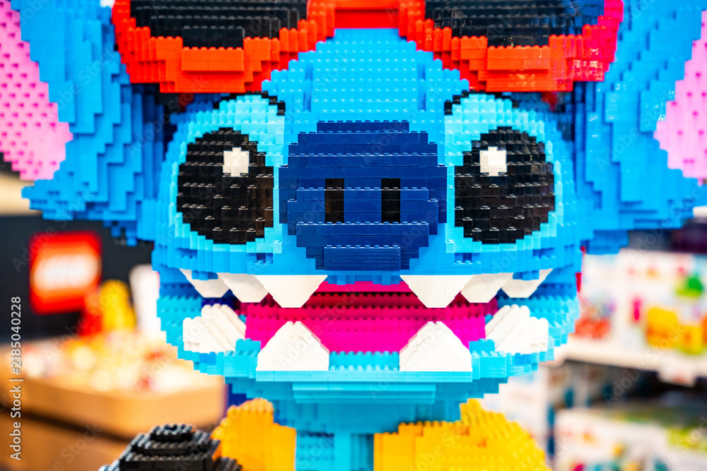 Obraz premium Bangkok, Thailand - September 4, 2026 : A large LEGO sculpture of Stitch from Disney Lilo & Stitch wearing sunglasses and a yellow shirt, holding a microphone.
