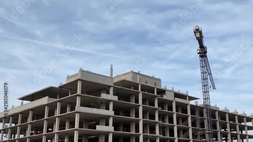 Concrete building under construction with tower crane