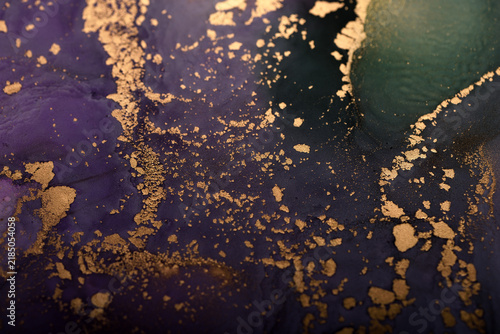 Abstract background of purple-green and gold stains. Close-up photo.