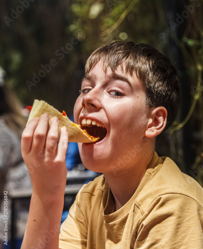 Young boy bites into a fresh taco with delight