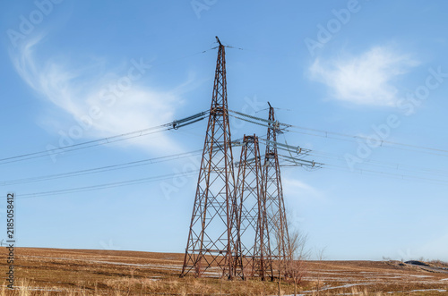 Power line to the field and the beautiful sky with clouds