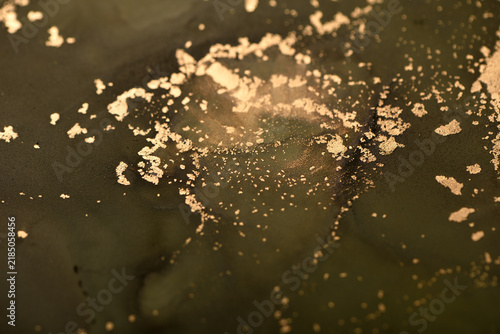 Abstract background of swamp-green and gold swirls; close-up photo.