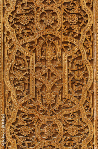 Uzbekistan. Exquisite wood carvings feature symmetrical floral motifs. Rich, warm tones highlight the artist's detailed work. Circular and foliate patterns are repeated throughout the elegant design.