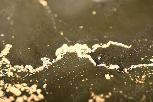 Abstract background of swamp-green and gold swirls; photo of a surface.