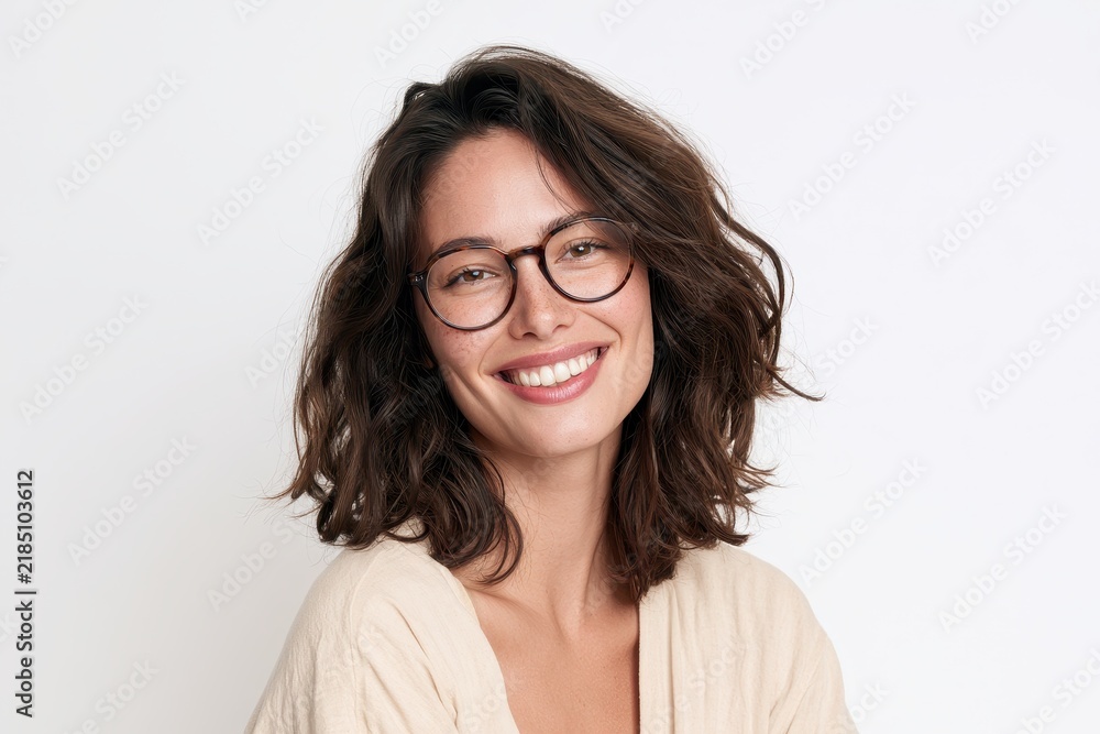 Fototapeta premium Bright studio portrait of a happy brunette with eyewear on a plain white background