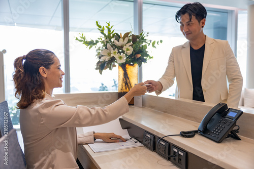 Receptionist assisting guest at office front desk