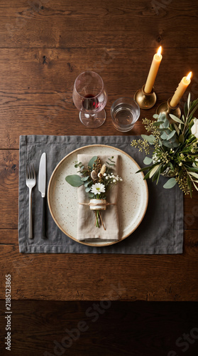 Elegant dinner table setting with wine and candles on wooden surface