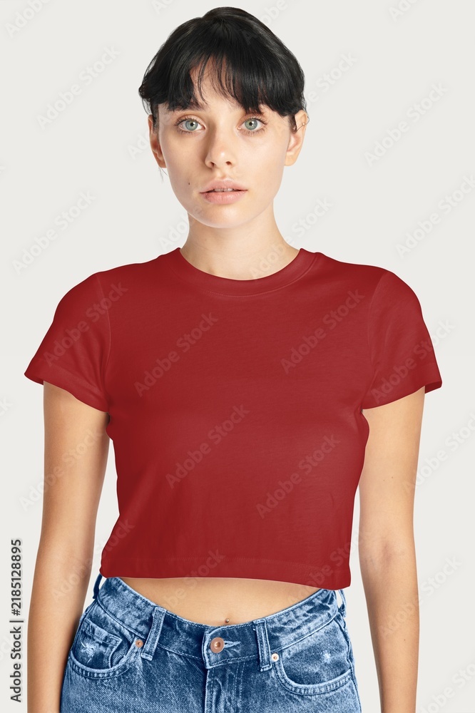 Obraz premium Young woman in red crop top and jeans on white background