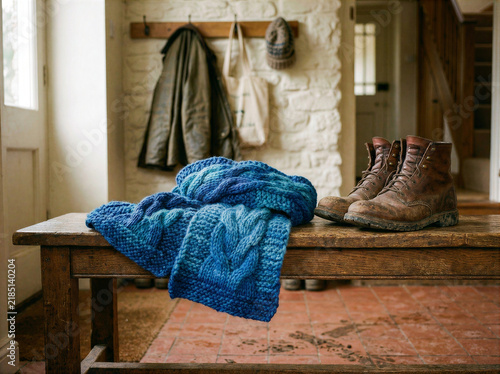 Blue Knitted Blanket on Rustic Wooden Bench in Cozy Entryway with Boots