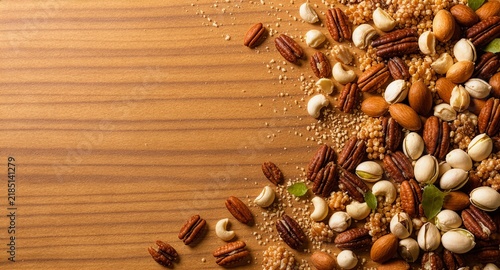 A beautiful assortment of healthy mixed nuts with dynamic crumbles scattered across a light wood table background, creating a perfect border for National Nut Day text space