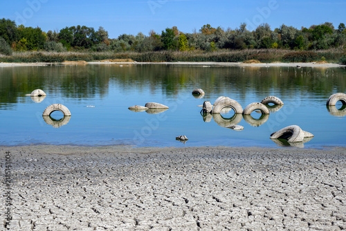 Принти на полотні A calm lake reflects the blue sky and surrounding foliage