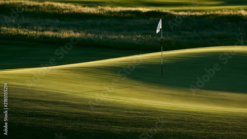 Golf course landscape with flag at sunset in a quiet setting