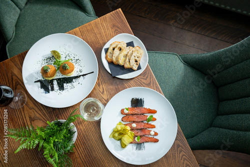 Quadro su tela Delicious Gourmet Dishes Served Elegantly on a Wooden Table in a Cozy Setting