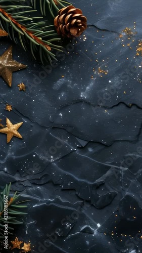 A winter holiday scene featuring golden stars and pine branches with cones scattered on a dark, textured surface accented by golden glitter. Ideal for seasonal backgrounds and celebrations.