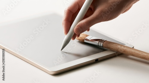 Hand Using Stylus and Paintbrush on Tablet Surface for Creative Digital Art