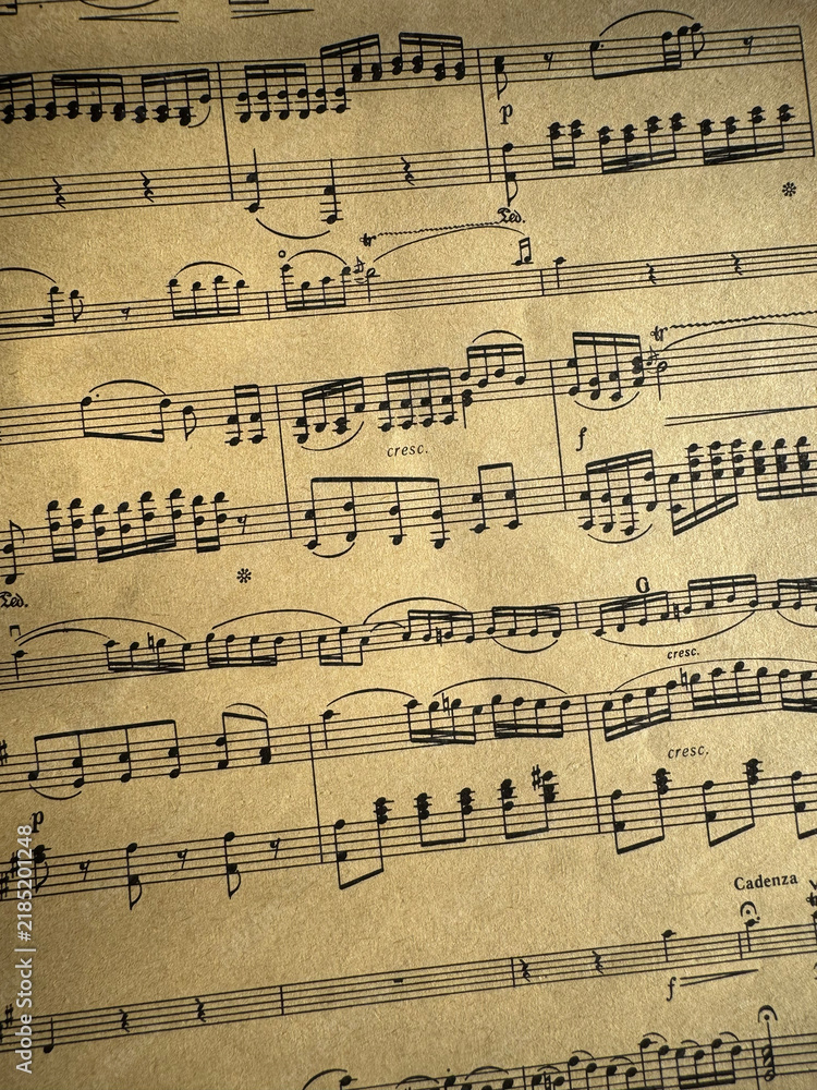 Fototapeta premium Close up of aged sheet music with musical notes and textured paper. Music notes Sheet on Aged Paper, black notes on brown paper, musical score, sheet music, musical notation, classical music 