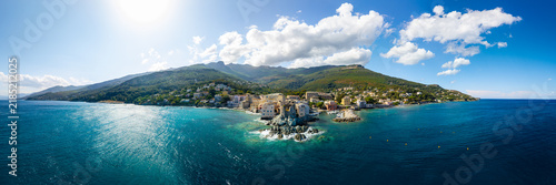 Erbalunga Cap Corse Corsica 10K drone panorama photo. Genoese tower on rocks with crashing waves and old village houses overhanging water in golden hour. High resolution World Print fine art aerial