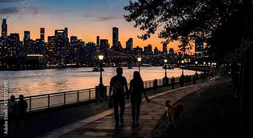 Couple walking dog along waterfront promenade with city skyline at dusk and soft ambient light